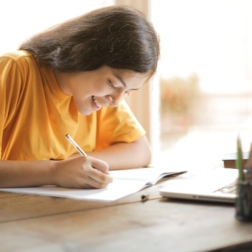 Woman writing in a notebook during a club session